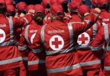 foto da dietro di un gruppo di persona con indosso una giacca della croce rossa italiana