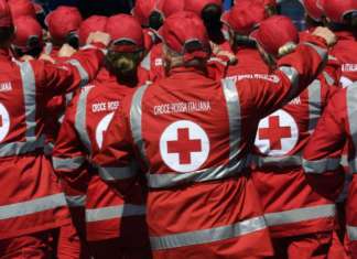 foto da dietro di un gruppo di persona con indosso una giacca della croce rossa italiana